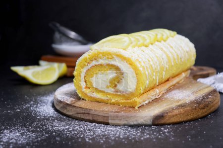 Foto de Close up of delicious vanilla cake roll with lemon butter cream inside, grey marble table - Imagen libre de derechos