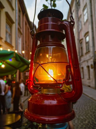 Foto de Antigua linterna roja de queroseno en la calle de la ciudad cerca de un café - Imagen libre de derechos