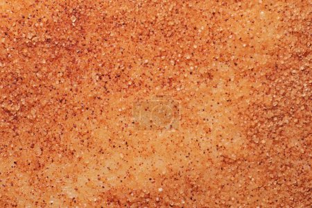 Granulated sugar and ground cinnamon close-up on the surface of the dough, macro photo
