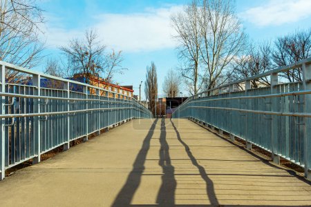 New pedestrian bridge with iron railings. Empty footbridge on a sunny day