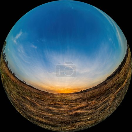 Sunset and sky over the meadow. Circular fisheye view of a spring landscape in the countryside. Panorama in fulldome photo format