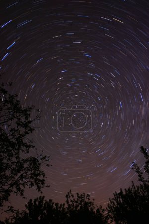 Colored star trails in the night sky around the North Pole and Polaris. Night landscape, astrophotography