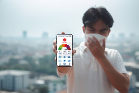PM2.5 affectant les voies respiratoires, les hommes portent des masques pour se protéger de la poussière et de la fumée. Application sur smartphone écran la concentration de polluants atmosphériques l'indice de qualité de l'air dangereux (IQA).