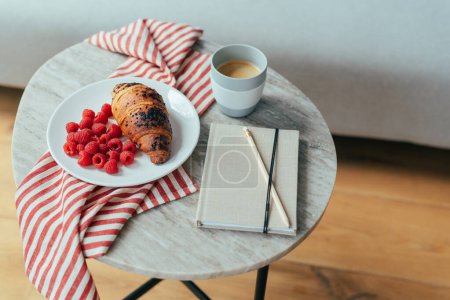 Photo for A cup of coffee with a chocolate croissant and raspberries for breakfast. - Royalty Free Image