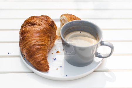 Foto de Croissant crujiente y café fresco en la cafetería al aire libre. Desayuno, concepto de almuerzo. - Imagen libre de derechos