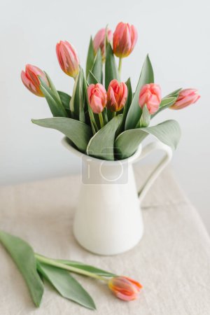 Foto de Ramo de delicados tulipanes rosados en una jarra. - Imagen libre de derechos
