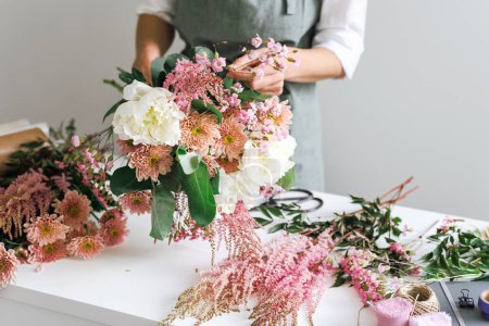 View of a desktop in a flower boutique covered with flowers.