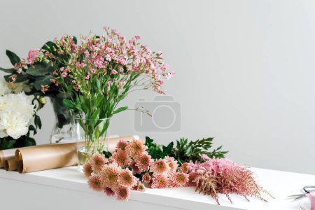 View of a desktop in a flower boutique covered with flowers.