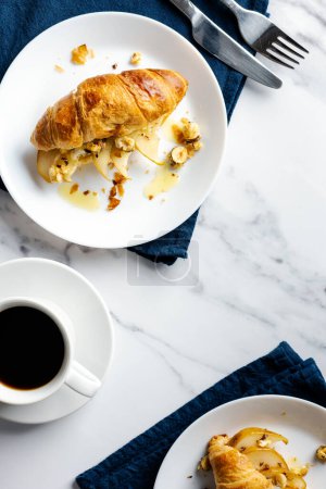 Foto de Café de la mañana con croissants rellenos de pera caramelizada, avellanas y ricotta. - Imagen libre de derechos