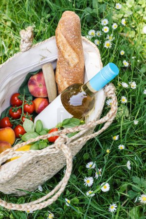 Foto de Botella de vino blanco y fruta fresca en una manta de picnic. - Imagen libre de derechos