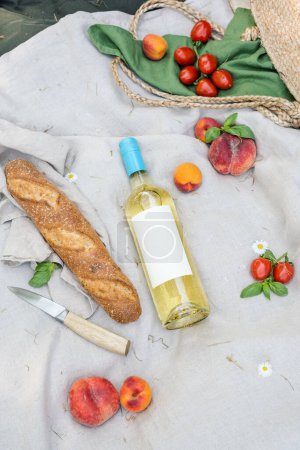 Foto de Botella de vino blanco y fruta fresca en una manta de picnic. - Imagen libre de derechos