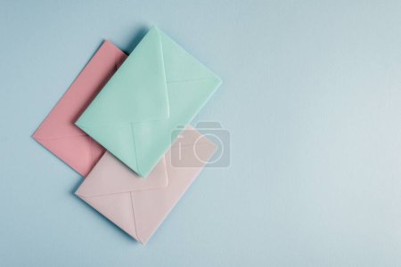 Téléchargez les photos : Collection d'enveloppes aux couleurs pastel sur fond bleu clair. - en image libre de droit