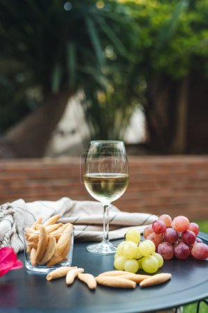 Photo for A glass of white wine with appetizers on the table. - Royalty Free Image