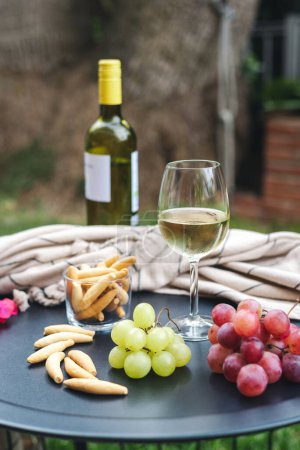 Téléchargez les photos : Un verre de vin blanc avec des entrées sur la table. - en image libre de droit
