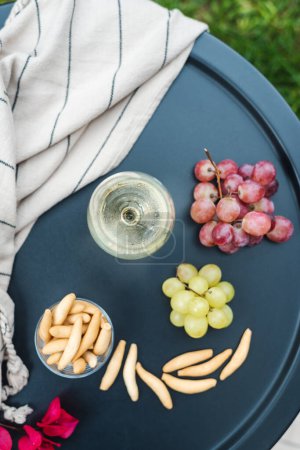 Foto de Una copa de vino blanco con aperitivos en la mesa. - Imagen libre de derechos