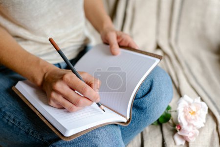 Photo for Woman makes notes in a notepad. - Royalty Free Image