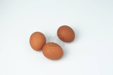Three chicken eggs are on a white background, isolated white