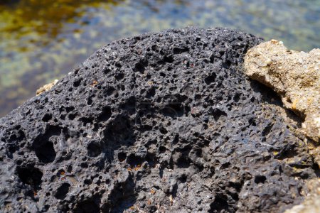 Photo for Porous black volcanic rock isolated on white background. Lava stone, pumice stone, or volcanic pumice with distinctive pores. - Royalty Free Image