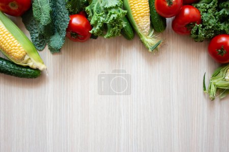 Téléchargez les photos : Légumes frais sur fond bois. Herbes aromatiques, maïs, concombre, tomates, chou frisé, chou frisé sur fond bois - en image libre de droit