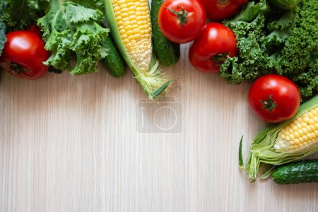 Photo for Fresh vegetables on wood background. Aromatic herbs, corn, cucumber, tomatoes, kale, leaf cabbage on wooden background - Royalty Free Image