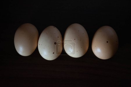 Photo for Farm eggs arranged on a black wooden background - Royalty Free Image