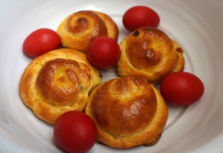 Photo for Easter bun bread and red eggs in a bowl. Romanian traditional food. Romanian sweet bread bun - Royalty Free Image