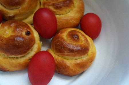 Photo for Easter bun bread and red eggs in a bowl. Romanian traditional food. Romanian sweet bread bun - Royalty Free Image