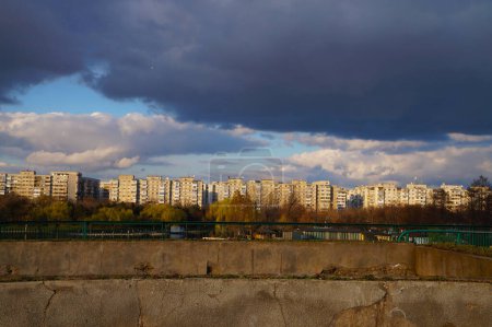 Photo for Bucharest, Tineretului neighborhood flats buildings at the sunset, seen from Tineretului Park. Dramatic sky - Royalty Free Image