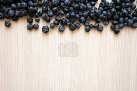 Photo for Fresh blueberries on wood backdrop. Close-up of blue berries on a light wood background - Royalty Free Image