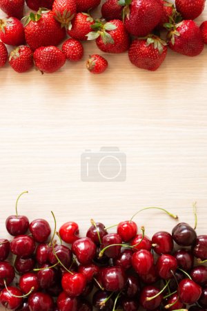 Photo for Cherry and strawberry fruits on a white wood background - Royalty Free Image