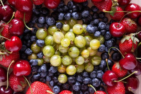 Photo for Berries variety arranged in a round shape. Berries background with cherry fruits, strawberries, gooseberry and blueberries. Healthy eating lifestyle concept. - Royalty Free Image