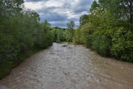 Foto de Río Bizdidel visto desde el puente de la aldea Diaconesti, Dambovita, Rumania, 2021, primavera. Aguas del río Muddy - Imagen libre de derechos