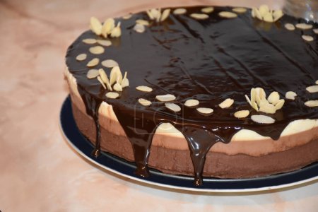 Téléchargez les photos : Gâteau mousse chocolat triple avec glaçage miroir chocolat et flocons d'amandes. Photo de haute qualité - en image libre de droit