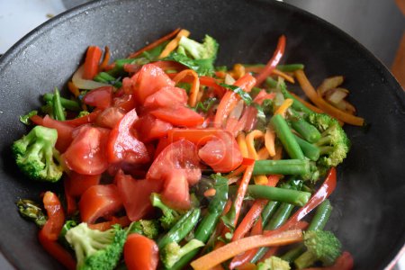 Photo for Stir fried vegetables in a pan at home. Mixing various vegetables in a pan closeup. High quality photo - Royalty Free Image