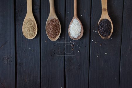 Photo for Jasmine rice in wooden bowl with wood ladle on old wood background, Dark tone, Copy space. High quality photo - Royalty Free Image