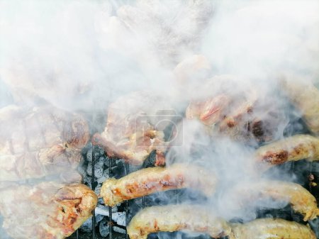 Photo for Pork steak and sausages cooked on the grill, on wood fire. Festive family day with BBQ. High quality photo - Royalty Free Image
