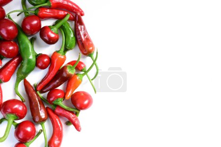 Photo for Pile of hot peppers border with space for text. Different green and red hot chili peppers frame isolated on white background. Cherry and small hot peppers - Royalty Free Image