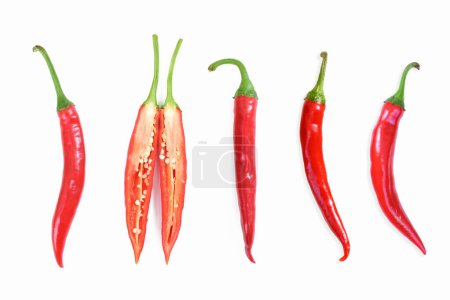 Photo for Red hot chili peppers. Chili pepper sliced, cross section. Four red long hot peppers and one chili pepper sliced in half. High quality photo - Royalty Free Image