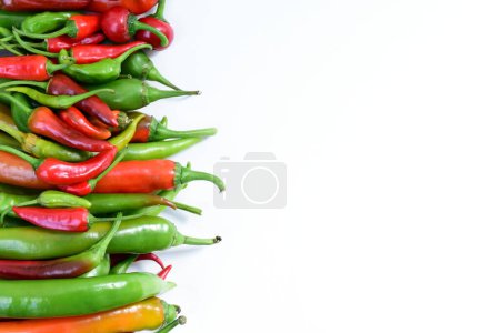 Photo for Pile of hot peppers border with space for text. Different green and red hot chili peppers frame isolated on white background. High quality photo - Royalty Free Image