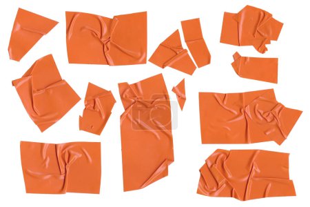 Klebeband-Stücke auf weißem Hintergrund. Orangefarbenes Isolationsklebeband. Papierband zerrissen und zerknitterte Stücke gesetzt. Hochwertiges Foto