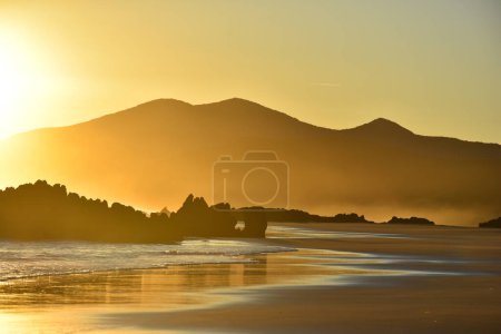 Téléchargez les photos : Lever de soleil sur la plage de Noja en Cantabrie, Espagne. Belle aurore dorée sur Noja. Horizontal Photo de haute qualité - en image libre de droit