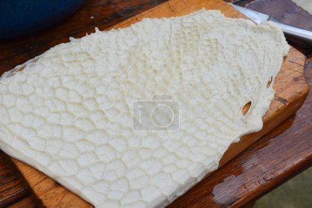 Clean beef tripe texture background on a wooden chopper. Cow raw stomach intestines texture for cooking. High quality photo