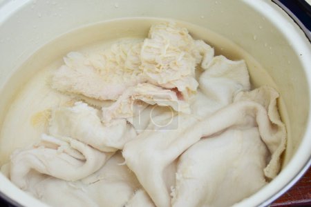 Putzen Sie Rindfleisch Kutteln bereit zum Kochen in einem Topf. Rohe Magen-Darm-Textur von Kühen zum Kochen. Hochwertiges Foto