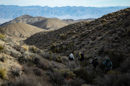 Téléchargez les photos : Quatre randonneurs masculins descendent dans le canyon Deadhorse, qui fait partie du populaire sentier de randonnée en boucle Cottonwood Canyon-Marble Canyon dans le parc national Death Valley en Californie. - en image libre de droit