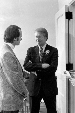 Téléchargez les photos : Jimmy Carter is approached by a younger member of the Newport, NH Rotary Club before he addresses the small crowd that has come to meet him. Circa April 1975. - en image libre de droit