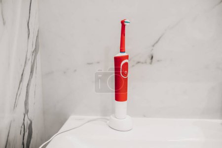 Foto de Cepillo de dientes eléctrico en el cargador en el baño - Imagen libre de derechos