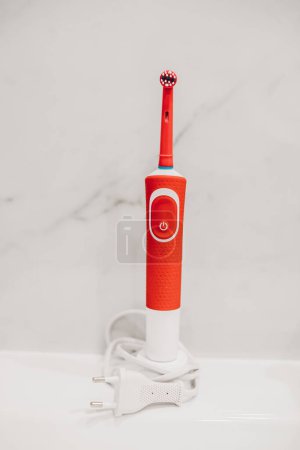 Photo for Electric toothbrush on the charger in the bathroom - Royalty Free Image