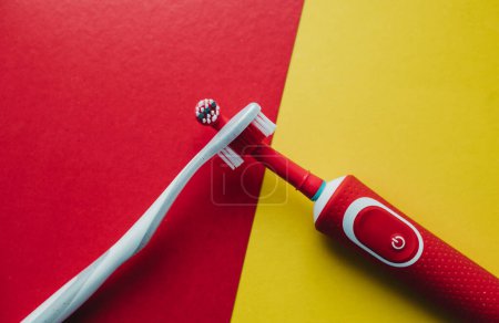 Foto de Cepillo de dientes eléctrico con boquillas de colores sobre un fondo de color - Imagen libre de derechos