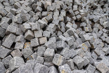 Photo for Close up of a pile of loose paving stones before being set into a road paved with setts - Royalty Free Image