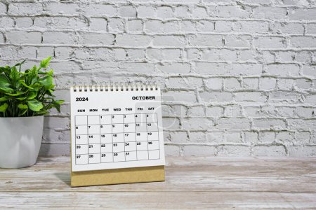 Téléchargez les photos : Calendrier blanc Octobre 2024 sur bureau bureau en bois avec plante en pot. Concept du Nouvel An 2024 - en image libre de droit